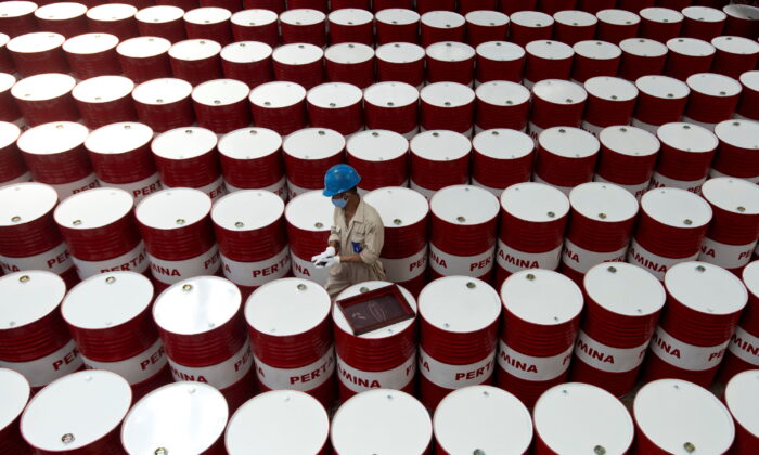 一名工人准备在 2017 年 11 月 6 日在印度尼西亚中爪哇 Cilacap 的国有石油公司 Pertamina 的润滑油生产设施给润滑油桶贴标签。（Antara Foto/Rosa Panggabean/ 来自路透社）