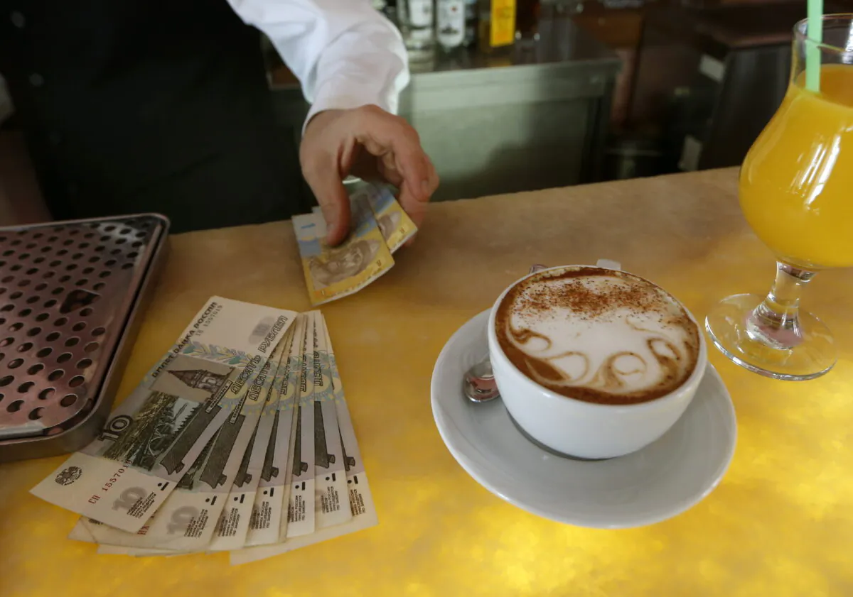 A waiter counts Russian rubles and prepares Ukrainian hryvnia for change in a restaurant in Sevastopol, Ukraine, on March 24, 2014. (Vasily Fedosenko/Reuters)