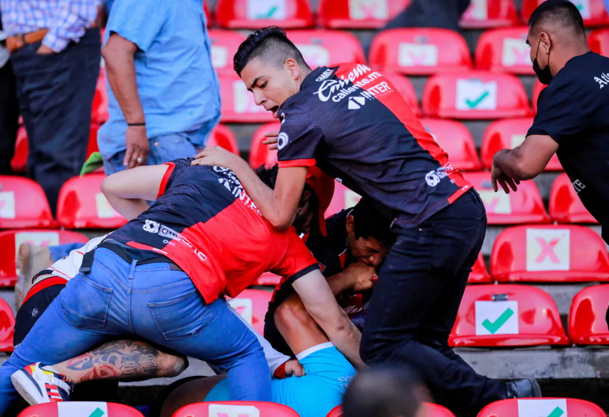 People are beaten in a brawl at the seating area of the Corregidora stadium  in Queretaro, Mexico, on March 5, 2022. (Victor Pichardo/Reuters)