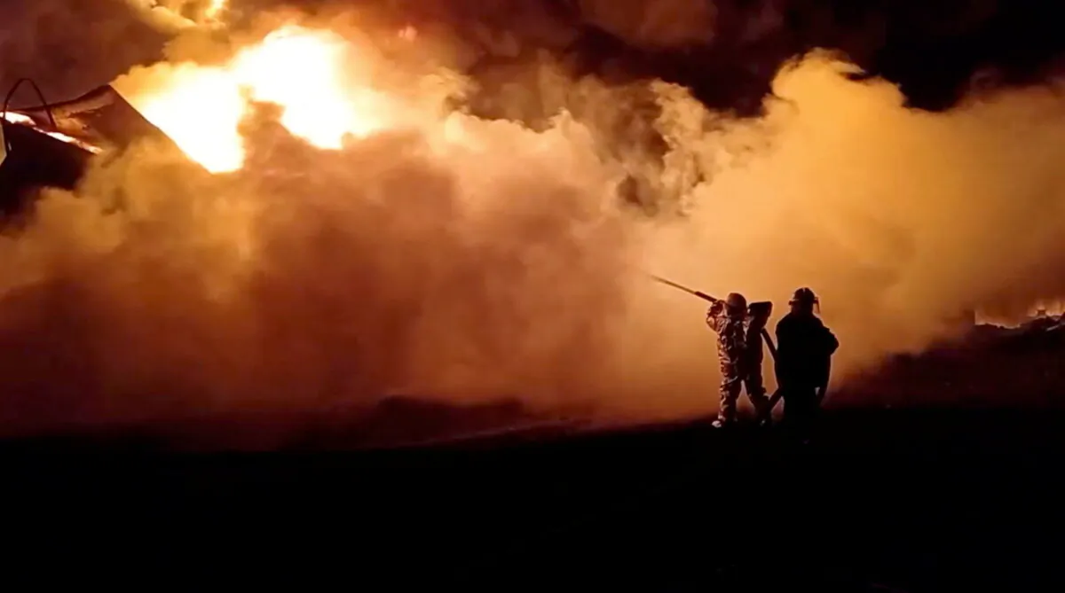 Fire fighters extinguish fire in an oil depot that Ukraine's State Emergency Services say was caused by Russian strikes in Zhytomyr region, Ukraine March 7, 2022 in this still image obtained from a handout video. State Emergency Services of Ukraine/Handout via REUTERS  