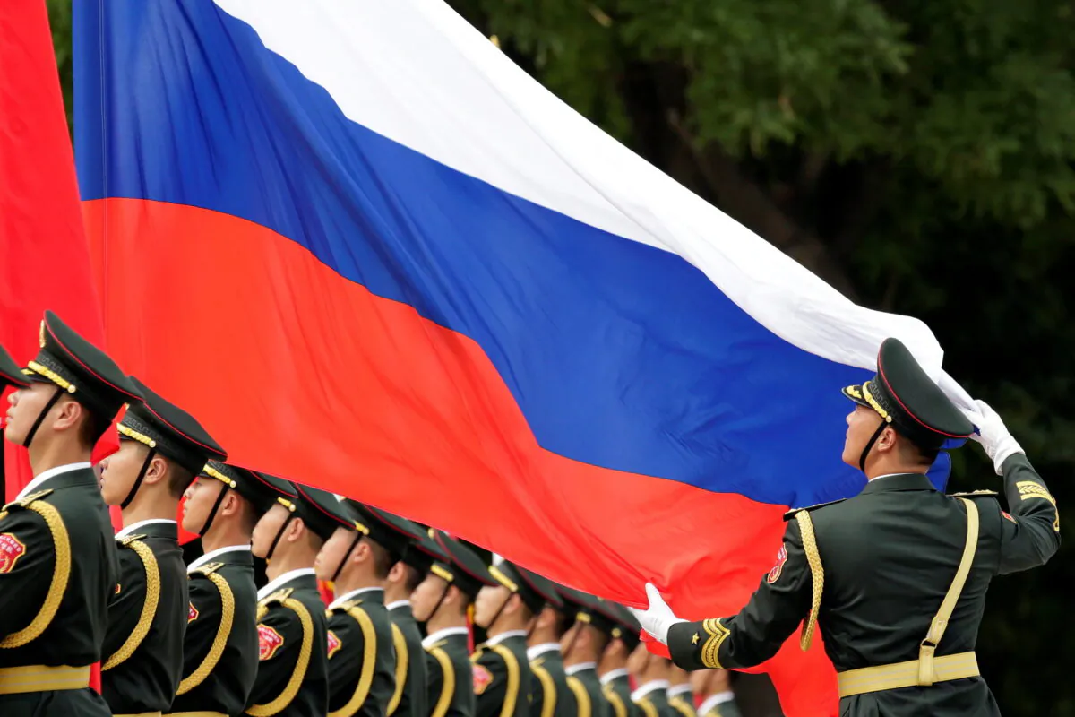 An honour guard holds a Russian flag during preparations for a welcome ceremony for Russian President Vladimir Putin outside the Great Hall of the People in Beijing, China, on June 8, 2018. (Jason Lee/Reuters)