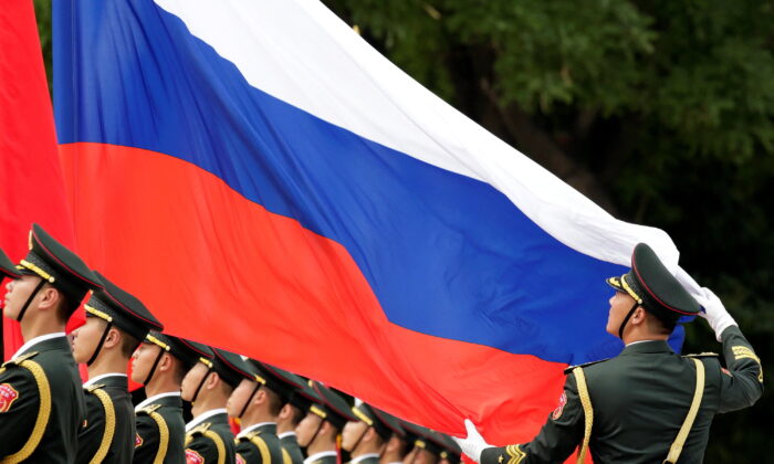 An honour guard holds a Russian flag during preparations for a welcome ceremony for Russian President Vladimir Putin outside the Great Hall of the People in Beijing, China, on June 8, 2018. (Jason Lee/Reuters)