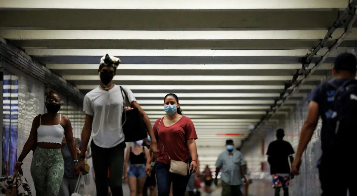 People wear masks as they pass through a pedestrian subway as cases of the infectious coronavirus Delta variant continue to rise in New York City, New York, on July 26, 2021. (Andrew Kelly/Reuters)