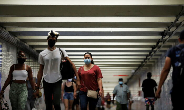 People wear masks as they pass through a pedestrian subway as cases of the infectious coronavirus Delta variant continue to rise in New York City, New York, on July 26, 2021. (Andrew Kelly/Reuters)