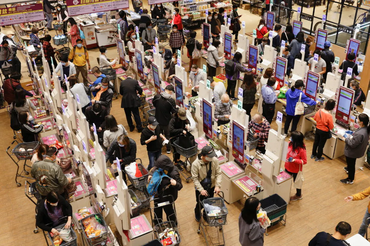 Customers wearing masks queue up to pay at a supermarket, ahead of mass coronavirus testing, in Hong Kong, on March 2, 2022. (Tyrone Siu/Reuters)