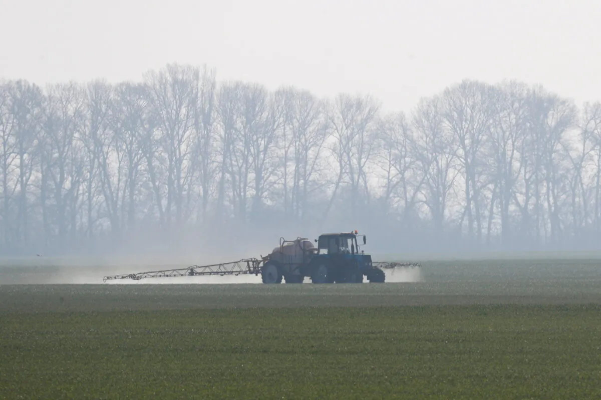 An agricultural worker drives a tractor spreading fertilizers to a field of winter wheat near the village of Husachivka in Kiev region, Ukraine April 17, 2020. (Valentyn Ogirenko/Reuters)