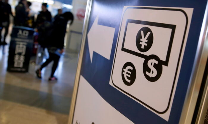 On March 25, 2016, the currency symbols of Japanese yen, euro, and US dollars are displayed on the bulletin board outside the currency exchange office at Narita International Airport near Tokyo, Japan.  (Yuya Shino / Reuters)