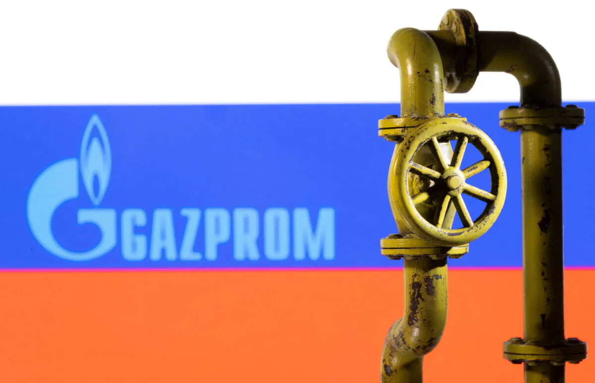 A 3D printed natural gas pipeline is placed in front of displayed Gazprom logo and Russian flag in this illustration taken on Feb. 8, 2022. (Dado Ruvic/Illustration/Reuters)
