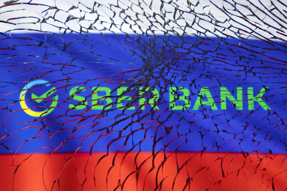 Sberbank logo and Russian flag are seen through broken glass in this illustration taken on March 1, 2022. (Dado Ruvic/Illustration/Reuters)

