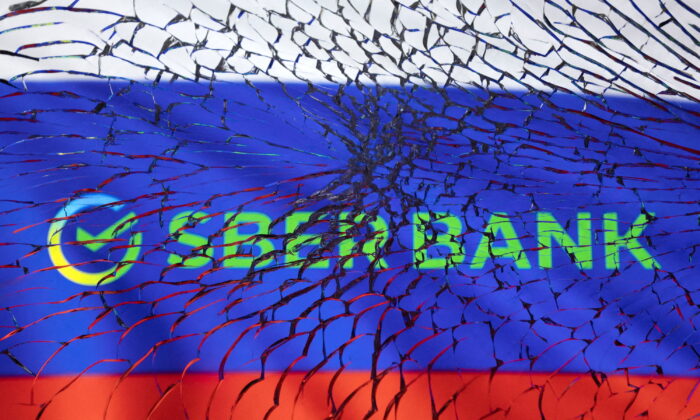 Sberbank logo and Russian flag are seen through broken glass in this illustration taken on March 1, 2022. (Dado Ruvic/Illustration/Reuters)

