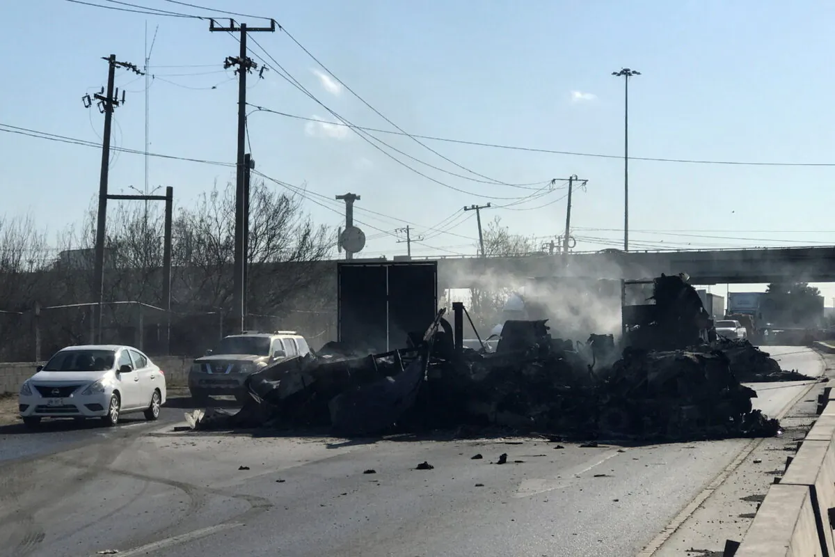 The charred wreckage of a trailer, which was set ablaze by suspected gang members following the detention of one of its leaders, is pictured in Nuevo Laredo, Mexico on March 14, 2022. (Stringer/Reuters)