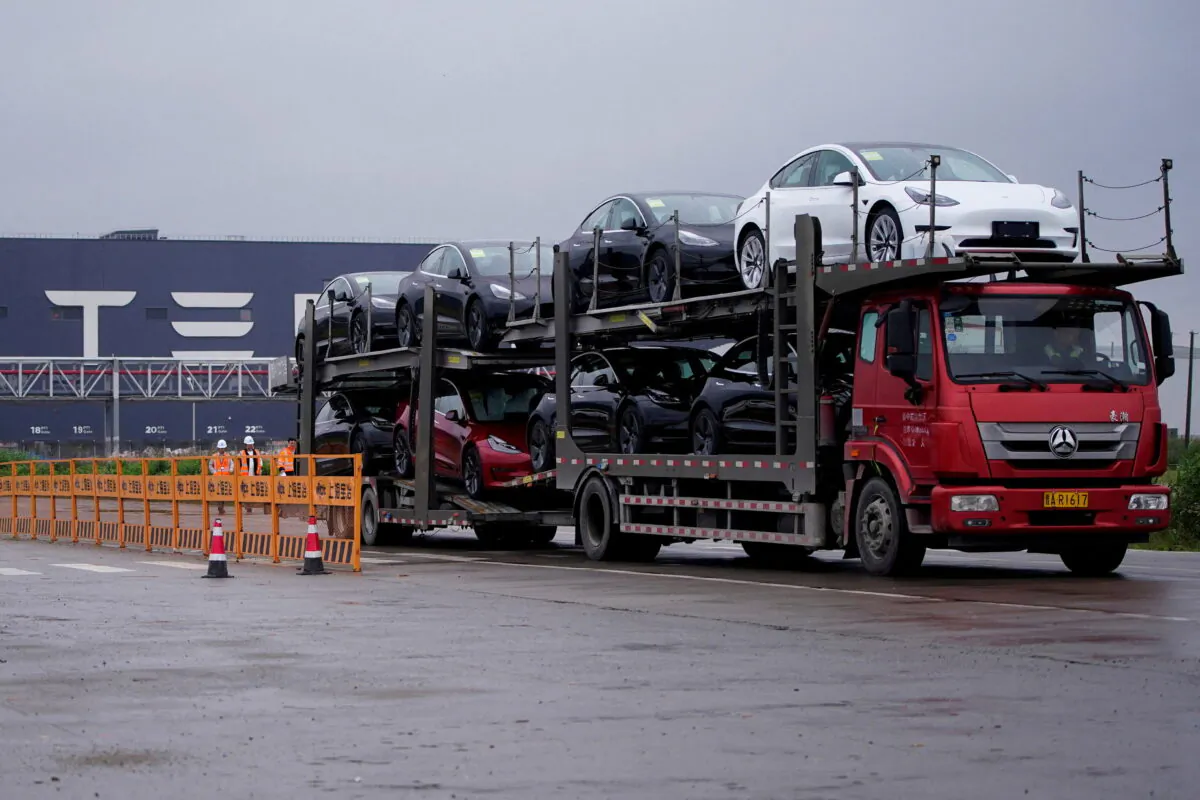 A truck transports new Tesla cars at its factory in Shanghai, China, on May 13, 2021. (Aly Song/Reuters)