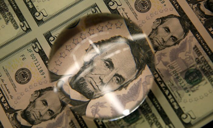 Sheets of former U.S. President Abraham Lincoln on the five-dollar bill currency are seen through a magnifying glass at the Bureau of Engraving and Printing in Wash., on March 26, 2015. (Gary Cameron/Reuters)