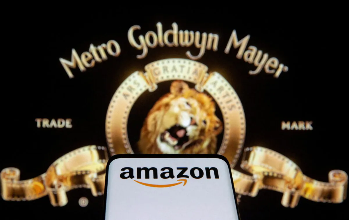 Smartphone with Amazon logo in front of displayed MGM logo in this illustration taken on May 26, 2021. (Dado Ruvic/Illustration/Reuters)