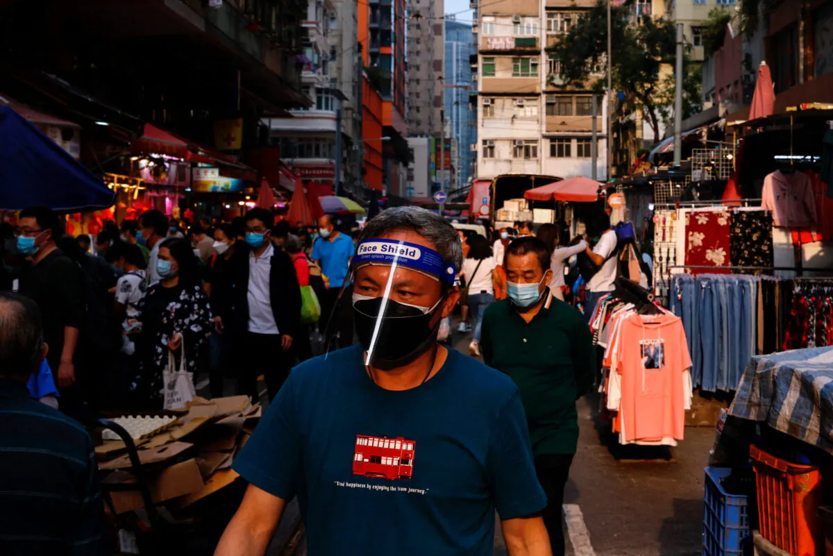 A man wearing protective mask and shield shops at wet market during the COVID-19 pandemic in Hong Kong on March 16, 2022. (Tyrone Siu/Reuters)
