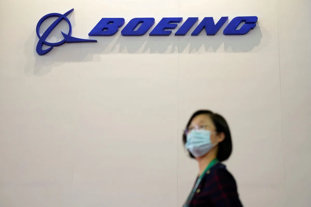 A woman walks past a Boeing logo at the China International Aviation and Aerospace Exhibition, or Airshow China, in Zhuhai, Guangdong province, China, on Sept. 28, 2021. (Aly Song/Reuters)