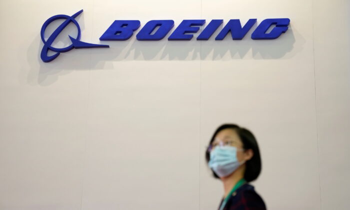 A woman walks past a Boeing logo at the China International Aviation and Aerospace Exhibition, or Airshow China, in Zhuhai, Guangdong province, China September 28, 2021. REUTERS/Aly Song