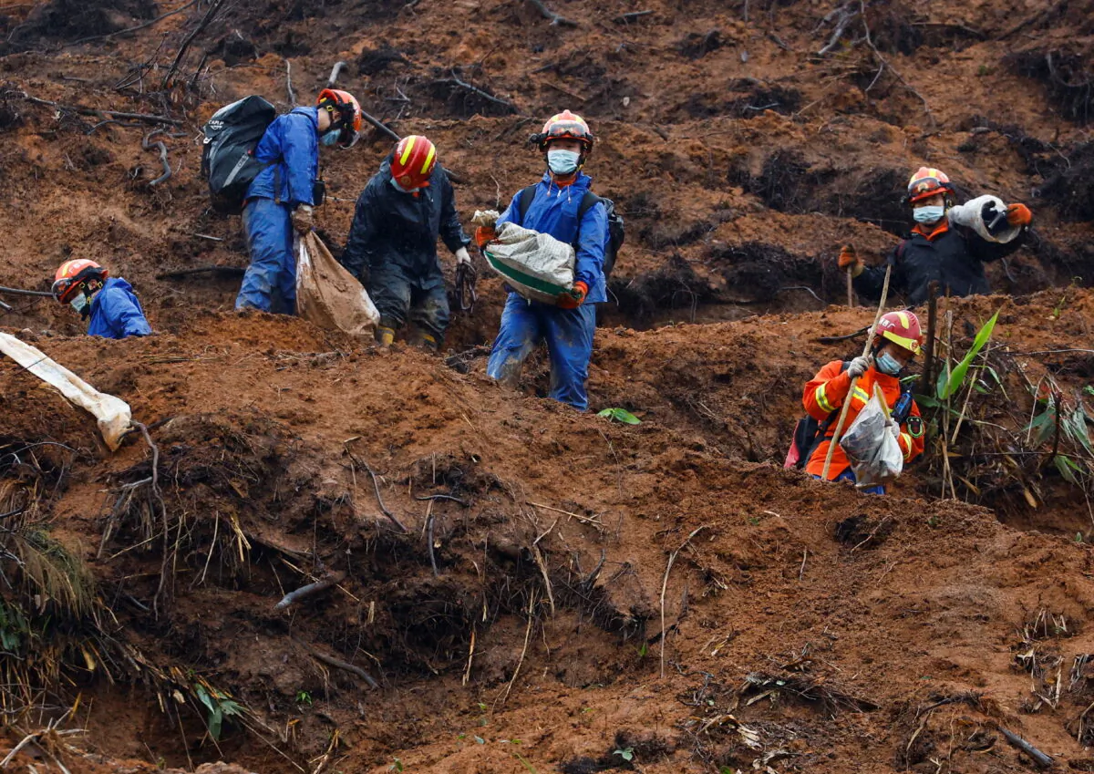 Rescue workers at the site where a China Eastern Airlines Boeing 737-800 plane, flying from Kunming to Guangzhou, crashed in Wuzhou, Guangxi Zhuang Autonomous Region, China, March 24, 2022. (Reuters/Carlos Garcia Rawlins)