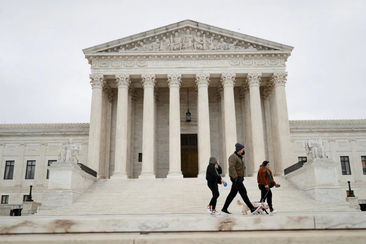 Visitors walking their dogs across the U.S. Supreme Court Plaza on Capitol Hill on Feb. 22, 2022. (Tom Brenner/Reuters)