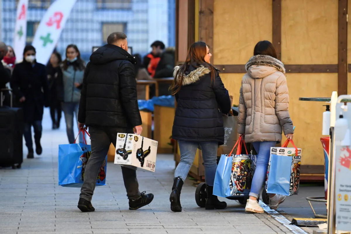 People with shopping bags walk near a shopping center, amid the coronavirus disease (COVID-19) pandemic, in Berlin, Germany, on Dec. 21, 2021.  (Annegret Hilse/Reuters)