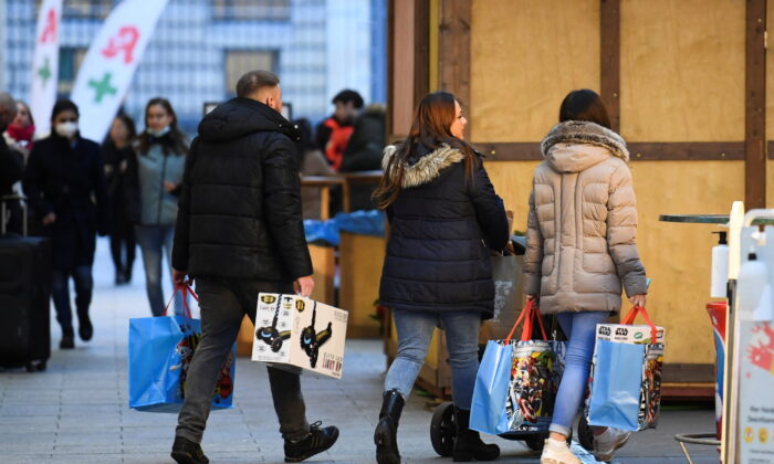 People with shopping bags walk near a shopping center, amid the coronavirus disease (COVID-19) pandemic, in Berlin, Germany, on Dec. 21, 2021.  (Annegret Hilse/Reuters)