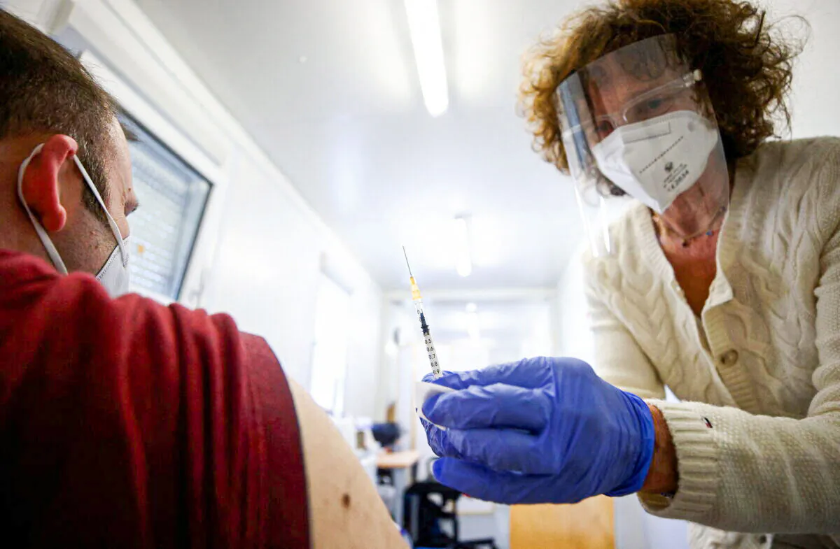 Doctor Eva Raunig vaccinates a person with a dose of the Pfizer-BioNTech COVID-19 vaccine inside a special container to use for general practitioners, called "vaccination box" in Vienna, Austria, on April 26, 2021. (Lisi Niesner/Reuters)