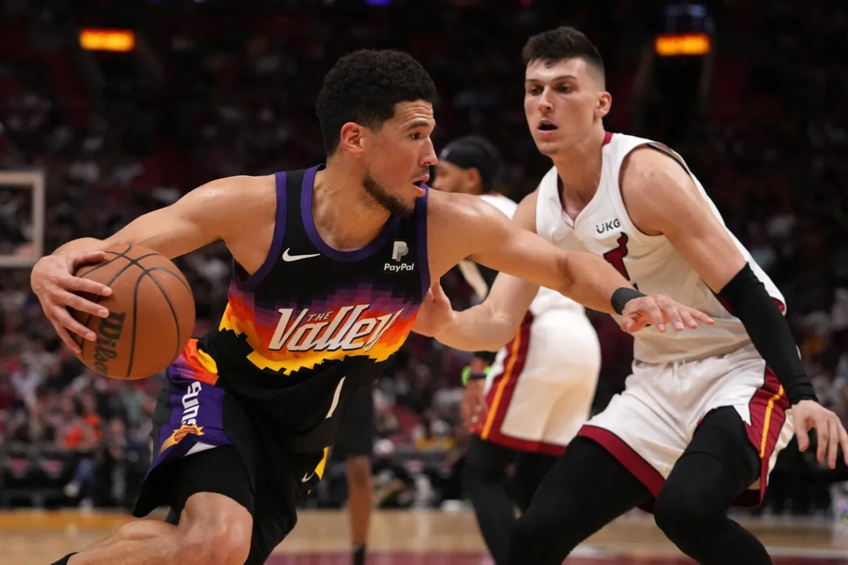 Phoenix Suns guard Devin Booker (1) drives the ball around Miami Heat guard Tyler Herro (14) during the first half at FTX Arena in Miami on March 9, 2022. (Jasen Vinlove/USA TODAY Sports via Field Level Media)