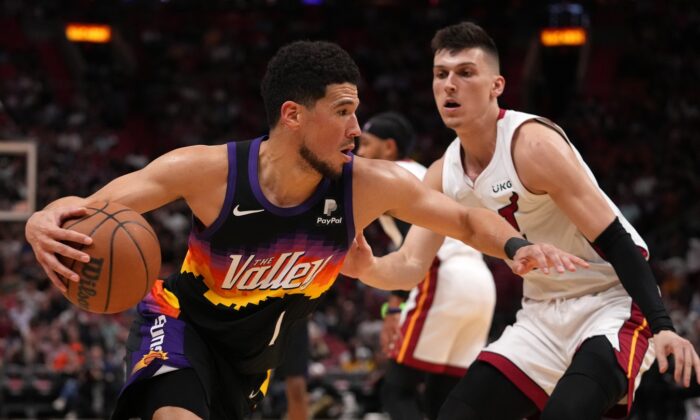 Phoenix Suns guard Devin Booker (1) drives the ball around Miami Heat guard Tyler Herro (14) during the first half at FTX Arena in Miami on March 9, 2022. (Jasen Vinlove/USA TODAY Sports via Field Level Media)