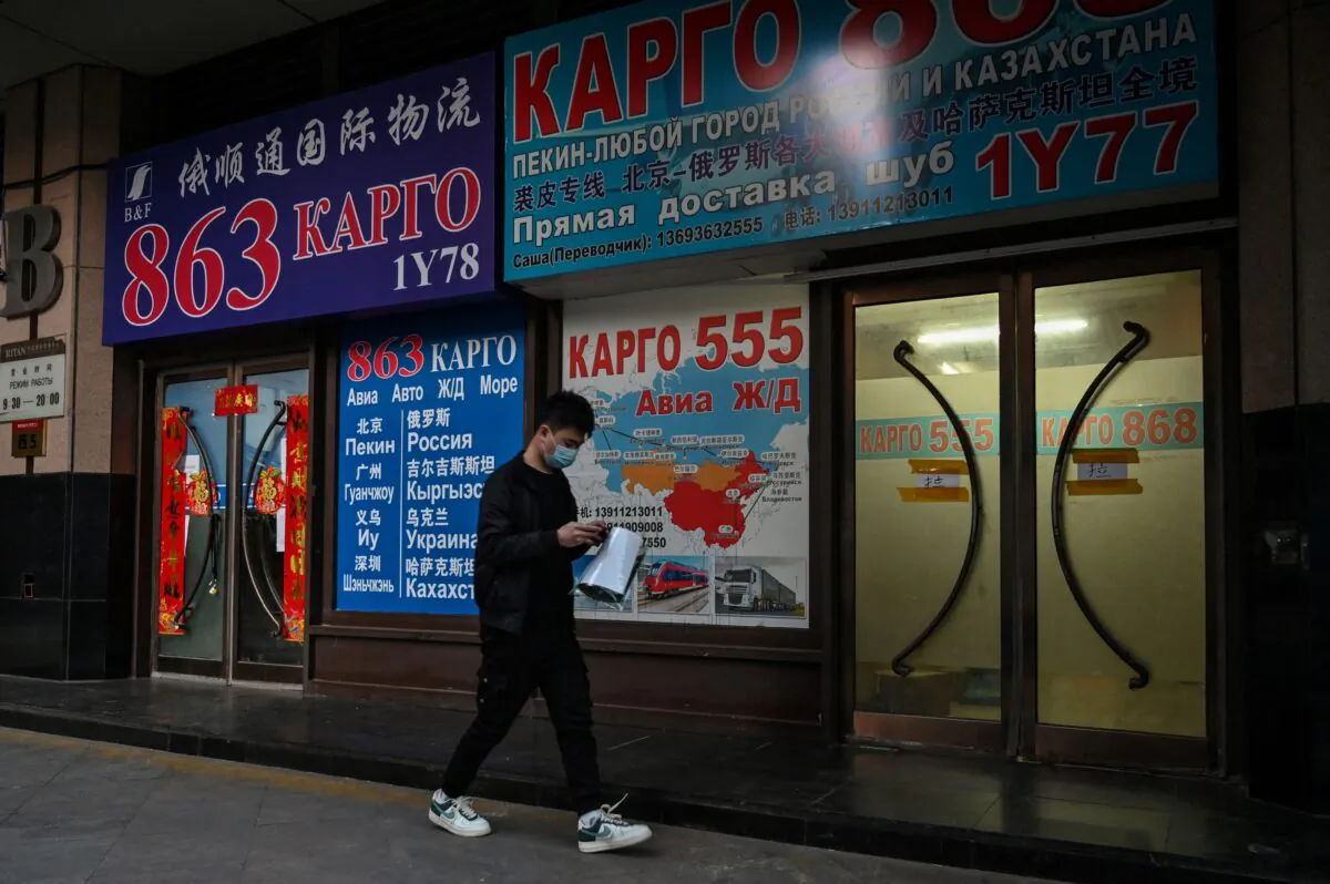 A man walks past a store advertising cargo shipping to Russia and other countries, along a street in Beijing on March 4, 2022. (Hector Retamal/AFP via Getty Images)