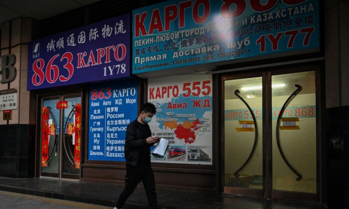 A man walks past a store advertising cargo shipping to Russia and other countries, in Beijing on March 4, 2022. (Hector Retamal/AFP via Getty Images)