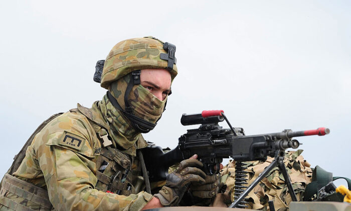 An Australian soldier from 7 Brigade operates a machine gun through the turret of a truck as part of exercise Talisman Sabre in Rockhampton, Australia, on July 9, 2015. (Ian Hitchcock/Getty Images)