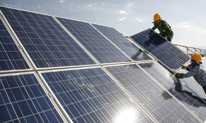 Workers install solar panels at a photovoltaic power station in Hami in northwestern China's Xinjiang Uyghur Autonomous Region on Aug. 22, 2011. (Chinatopix via AP)