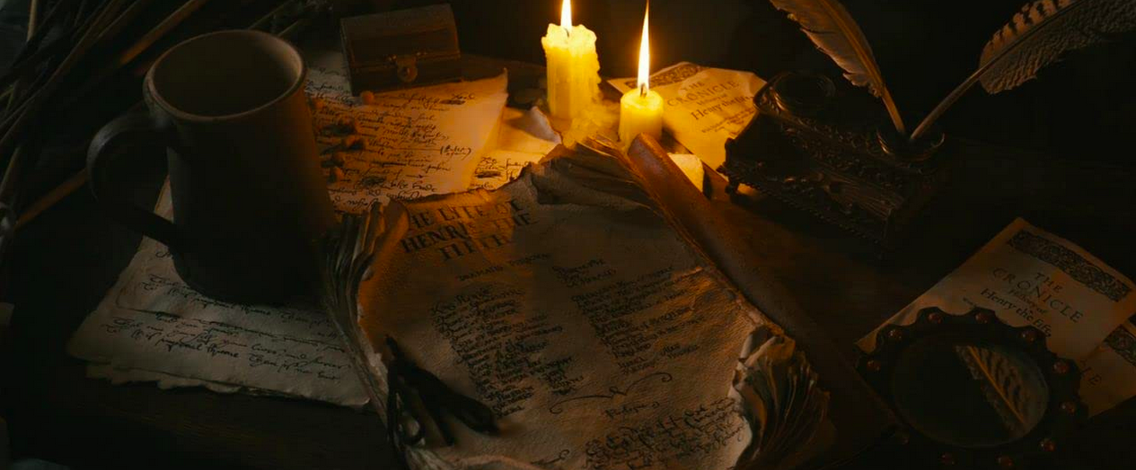 A writing desk strewn with scripts, in "Anonymous." 