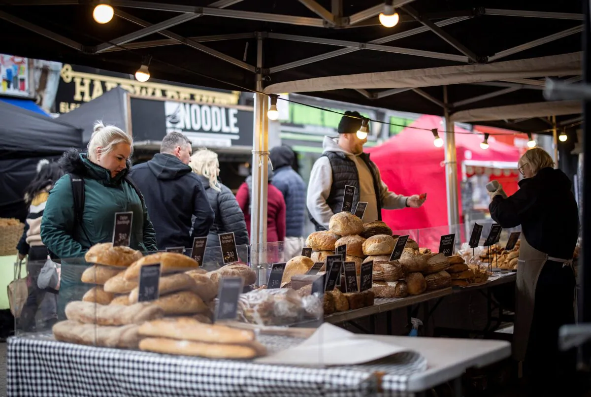 Customers shop for bread on a market stall in Walthamstow, east London on Feb. 13, 2022. (Tolga Akmen /AFP via Getty Images)