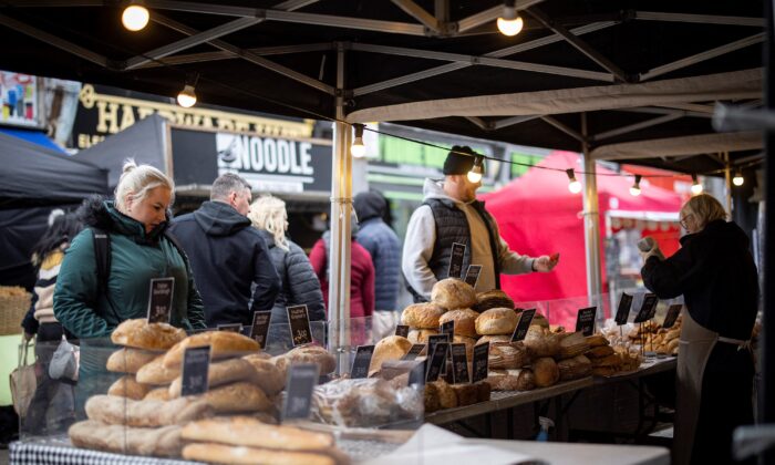 Customers shop for bread on a market stall in Walthamstow, east London on Feb. 13, 2022. (Tolga Akmen /AFP via Getty Images)