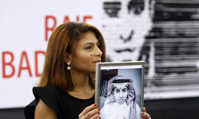  Ensaf Haidar, wife of the jailed Saudi Arabian blogger Raif Badawi, shows a portrait of her husband as he is awarded the Sakharov Prize, in Strasbourg, France, on Dec, 16, 2015. (AP Photo/Christian Lutz, File)