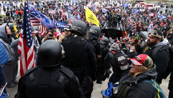 1 月 6 日，誓言守护者成员护送国会大厦警察穿过人群到达安全地带的国会大厦警察。