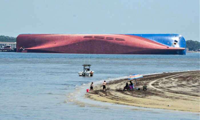 People are shown on Jekyll Island's Driftwood Beach as the Golden Ray cargo ship is capsized in the background, off the Georgia coast, on Sept. 8, 2019. (Terry Dickson/AP Photo)