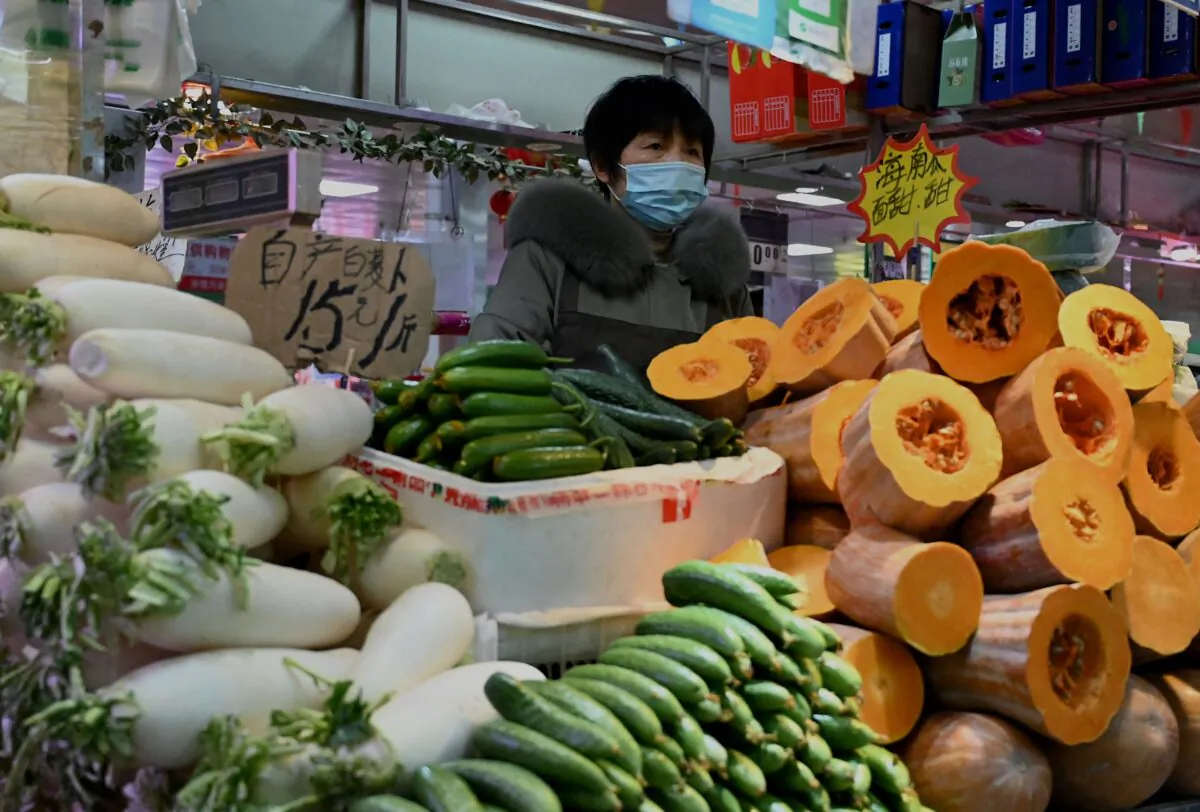 A vegetable vendor waits for customers at a market in Beijing on Jan. 17, 2022. (Noel Celis/AFP via Getty Images)