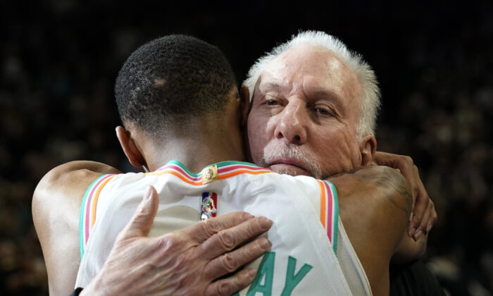San Antonio Spurs coach Gregg Popovich (R) is hugged by guard Dejounte Murray the team's NBA basketball game against the Utah Jazz in San Antonio, on March 11, 2022. (Eric Gay/AP Photo)