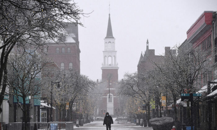 A man walks through Church Street Marketplace during a snowstorm in Burlington, Vt., on March 12, 2022. (Jessica Hill/AP Photo)