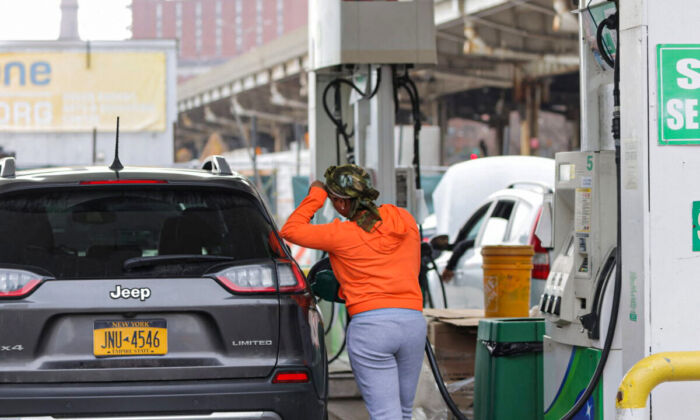 A person uses a petrol pump at a gas station as fuel prices surged in Manhattan, New York City, on March 7, 2022. (Andrew Kelly/Reuters)