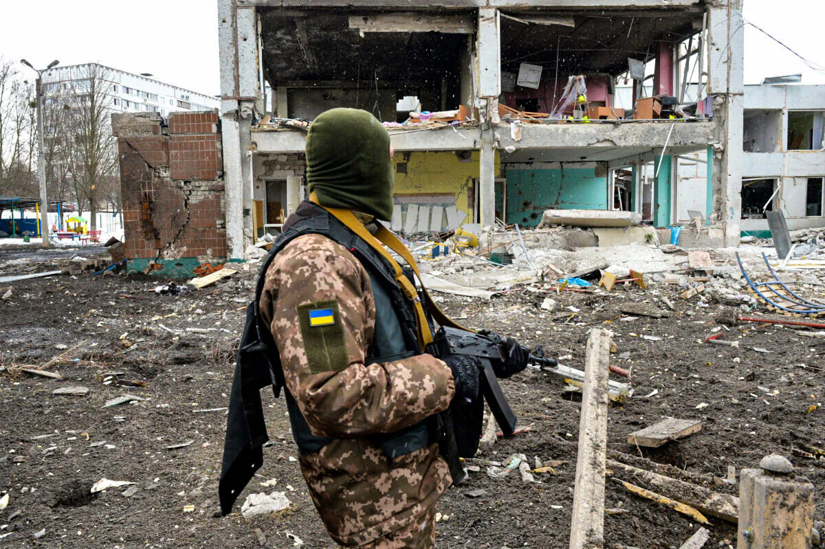 A member of the Ukrainian Territorial Defence Forces looks at destructions following a shelling in Ukraine's second-biggest city of Kharkiv on March 8, 2022. (Sergey Bobok/AFP via Getty Images)