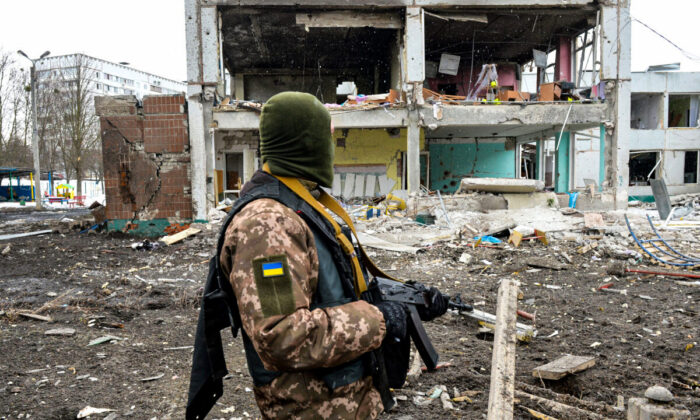 A member of the Ukrainian Territorial Defence Forces looks at destruction following a shelling in Ukraine's second-biggest city of Kharkiv on March 8, 2022. (Sergey Bobok/AFP via Getty Images)