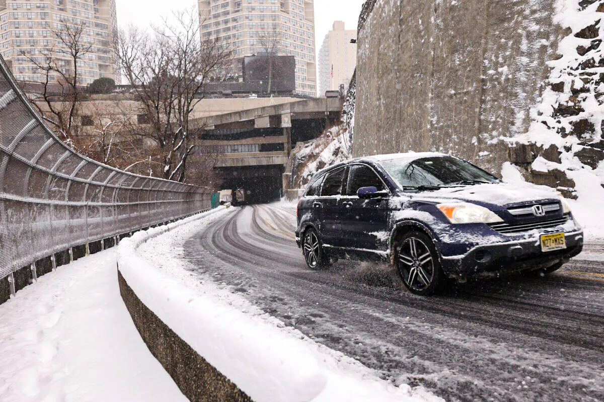 An S.U.V. slowly drives up a steep road covered in snow and slush in West N.Y., N.J., on Jan. 29, 2022. (Michael Loccisano/Getty Images)