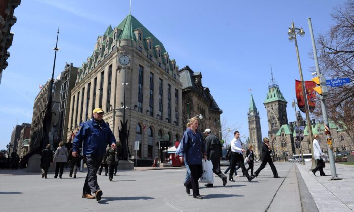 Pedestrians cross Elgin Street in view of the Peace Tower on Parliament Hill in Ottawa, in a file photo. (The Canadian Press/Sean Kilpatrick)
