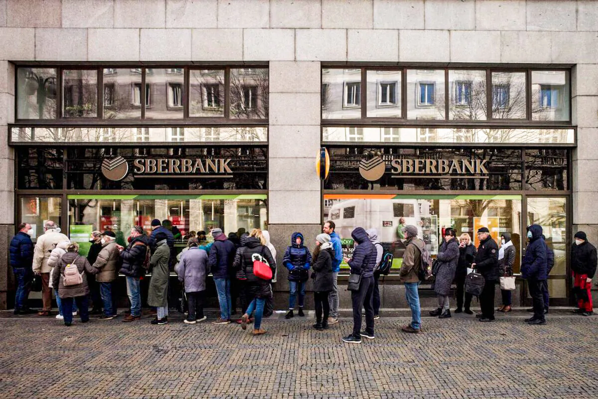 People queue outside a branch of Russian state-owned bank Sberbank to withdraw their savings and close their accounts in Prague on Feb. 25, 2022, before Sberbank closed all its branches in the Czech Republic later in the day. (Michal Cizek/AFP via Getty Images)