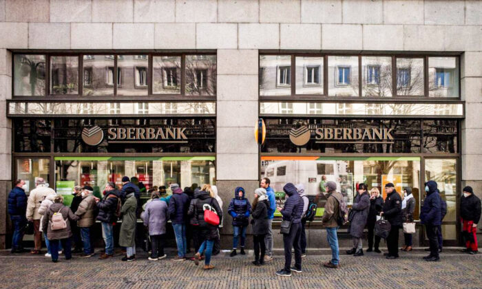 People queue outside a branch of Russian state-owned bank Sberbank to withdraw their savings and close their accounts in Prague on Feb. 25, 2022, before Sberbank closed all its branches in the Czech Republic later in the day. (Michal Cizek/AFP via Getty Images)