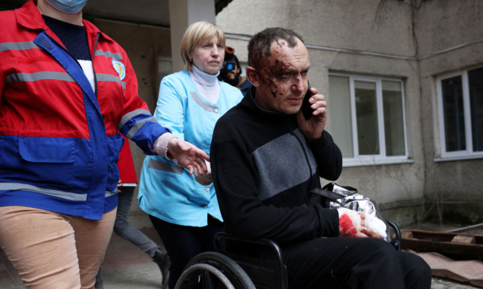 A man wounded in this morning's air strikes at a nearby military complex is assisted by medical staff outside Novoiavorivsk District Hospital on March 13, 2022 in Novoiavorivsk, Ukraine. (Dan Kitwood/Getty Images)