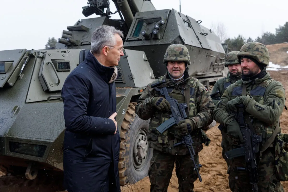 NATO Secretary General Jens Stoltenberg talks with soldiers during a visit of the Adazi military base, north east of Riga, Latvia, on March 8, 2022. (Toms Norde/AFP via Getty Images)